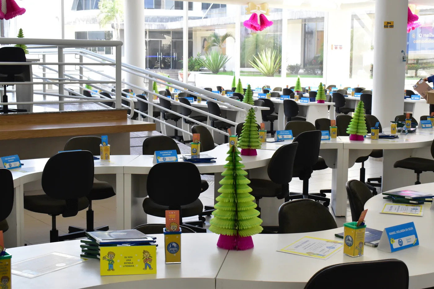 Ambiente amplo da escola com mesas e computadores